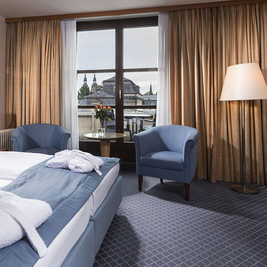 Superior room Elegant superior room at Maritim Hotel Fulda with double bed, seating area, and balcony overlooking the city.