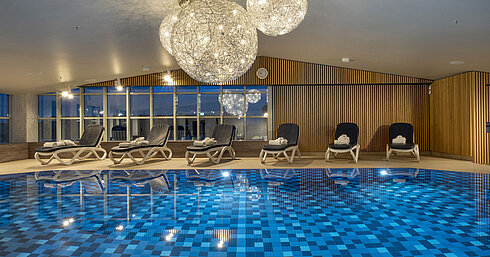 Pool Blue-tiled pool and lounge chairs at the Maritim Hotel Munich