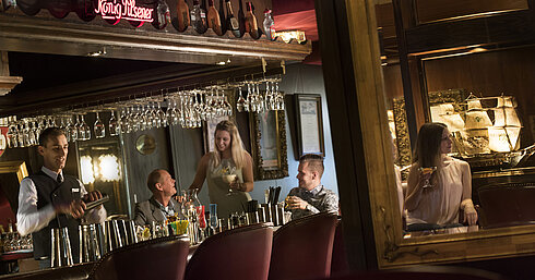 Backbord bar Atmospheric bar at the Maritim Hotel Kiel with guests enjoying cocktails while the bartender mixes a drink.