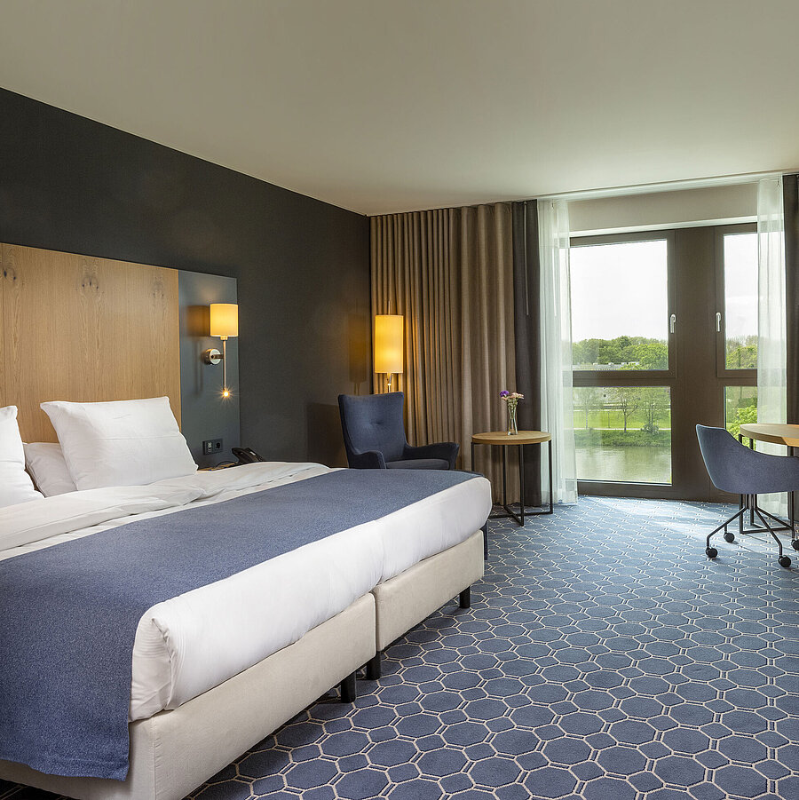 Superior room Spacious double room at Maritim Hotel Ingolstadt with bed, desk, and a view of the river.