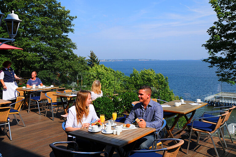 Panoramic terrace Panorama terrace at the Maritim Hotel Kiel with guests enjoying breakfast, a view of the fjord, sunny weather and a relaxed atmosphere.