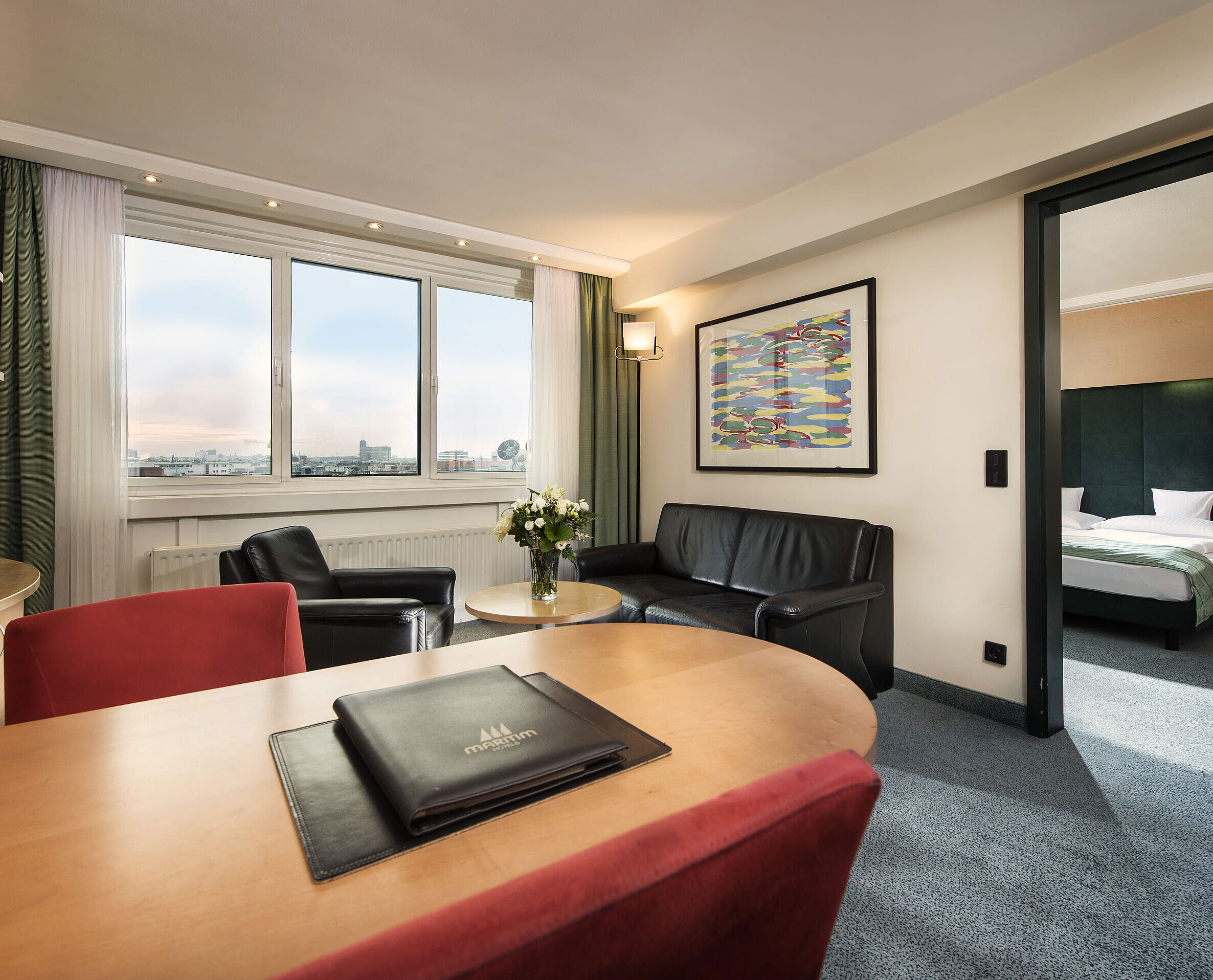 Family suite Junior suite at Maritim proArte Hotel Berlin with living area, desk, sofa, and separate bedroom with king-size bed.