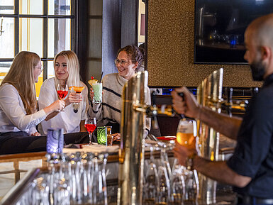 Bar Guests enjoying cocktails at the bar of the Maritim Hotel Würzburg.