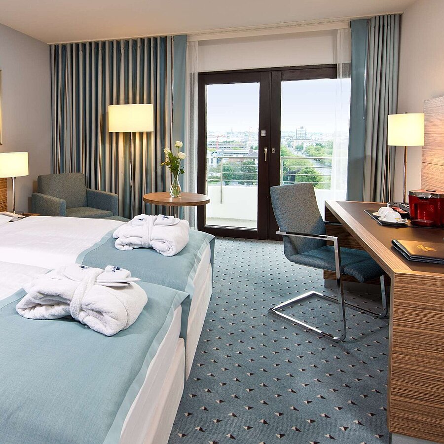 Superior room Superior room at Maritim Hotel Darmstadt featuring stylish design, desk, cozy seating area, and double bed with bathrobes.